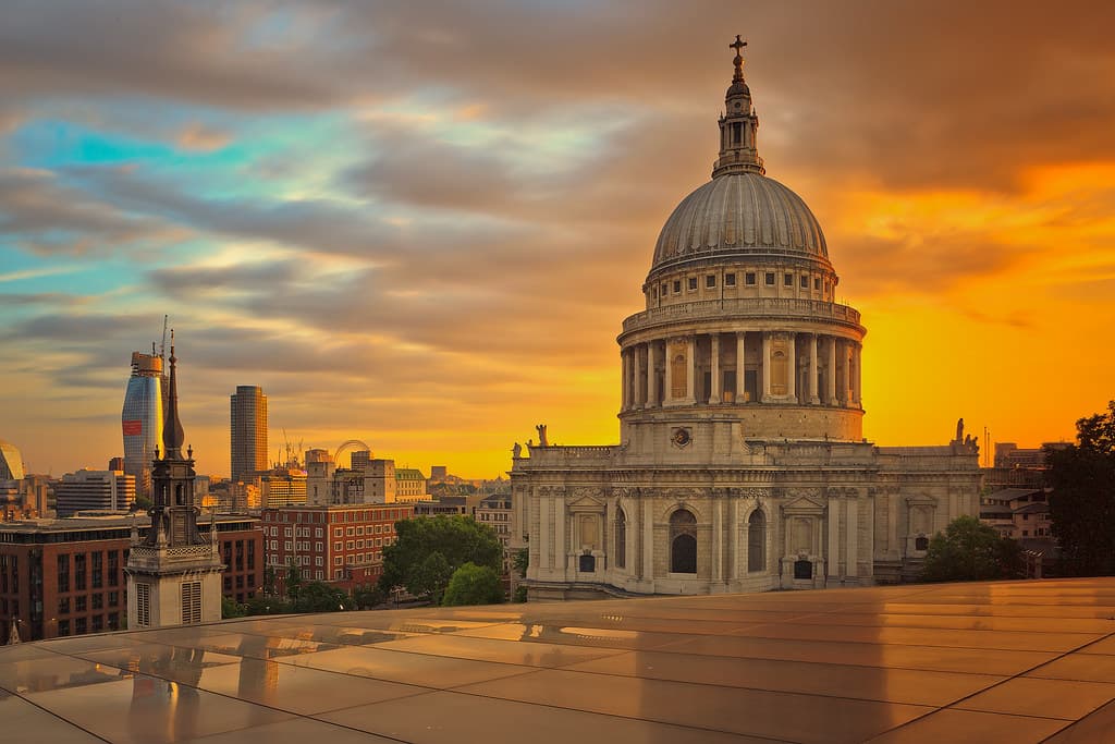 A building with a dome glowing in the sunset, casting a warm light over the surroundings.